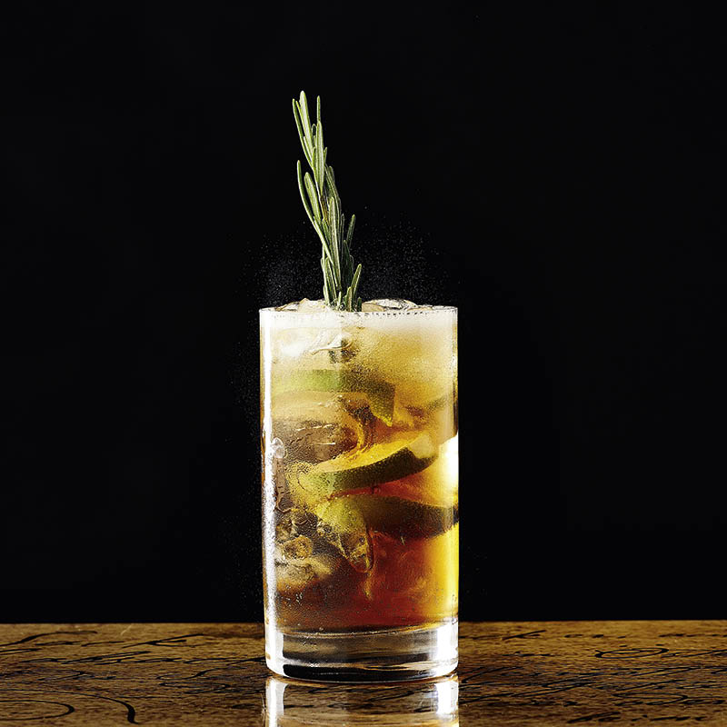 Absacker im Cocktailglas mit Rosmarin und Limette