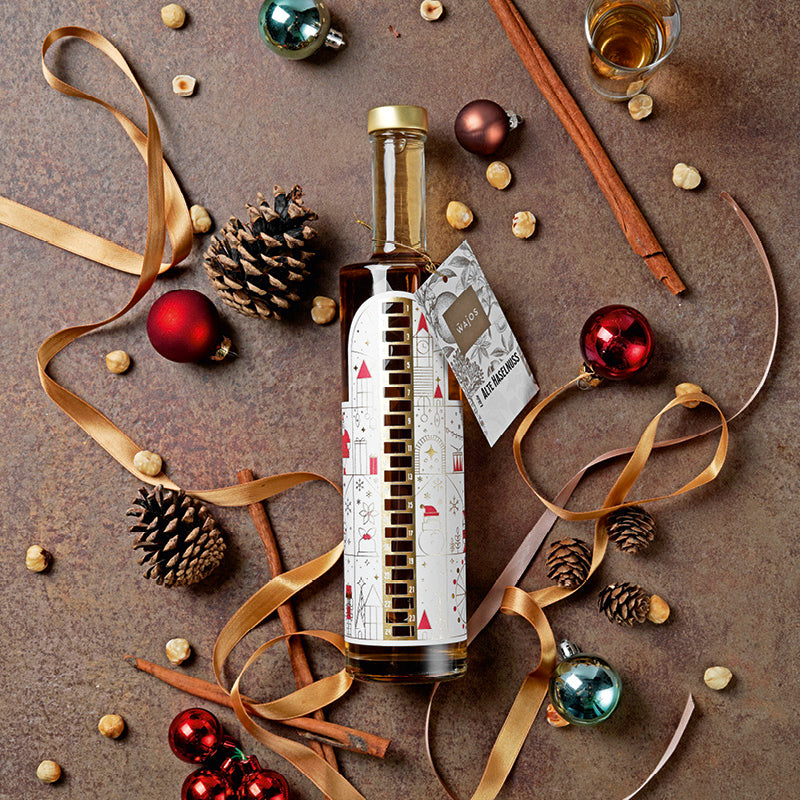 Wajos Adventskalender Flasche gefüllt mit Alte Haselnuss Likör dargestellt mit weihnachtlicher Deko