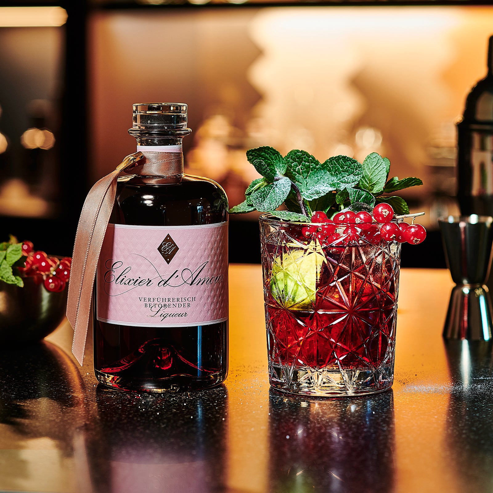 Elixier d&#39;Amour Liqueuer dargestellt mit Cocktail und Früchten
